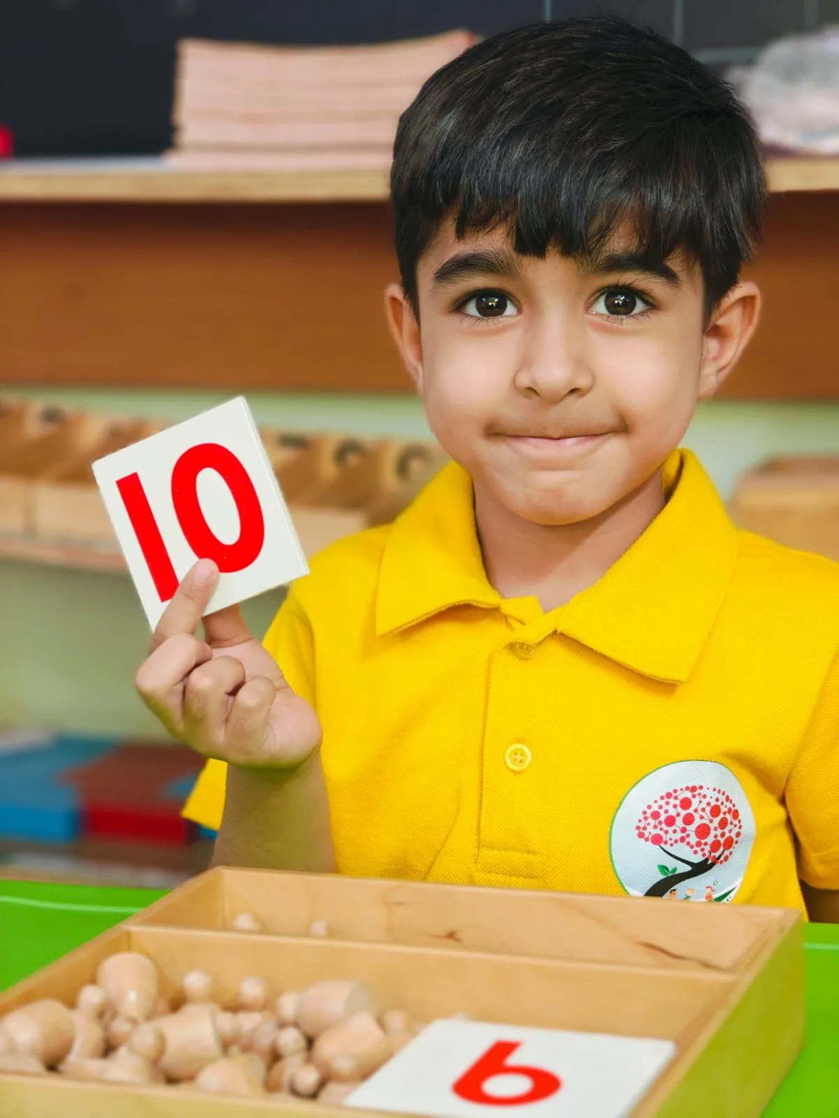 Child holding a Montessori number card